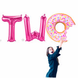 Girl holding a Donut Balloons to spell TWO for a sweet two 2nd birthday balloons banner inSilver - Gold - Rose Gold - Pink - Blue