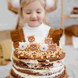 girl blowing out birthday cake with bear candles in white and brown