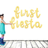 Girl holding Gold FIESTA Balloon Letter Banner 