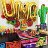 UNO spelled out with 34 inch gold letter balloons in rose gold