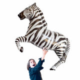 girl holding large black zebra balloons